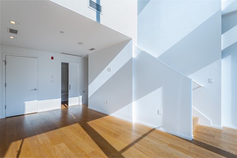 a living room with white walls and wooden floors